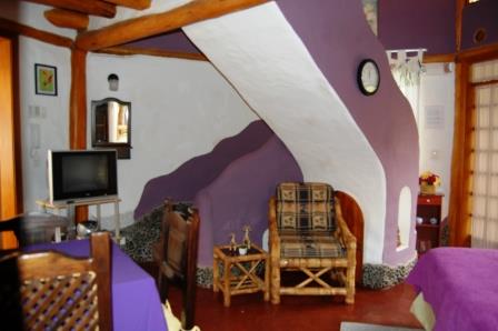 Rincón de descanso con sillón y pared morada.