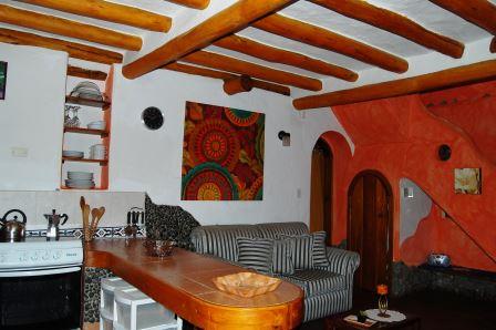 Sala-comedor con techo de madera y cocina abierta.