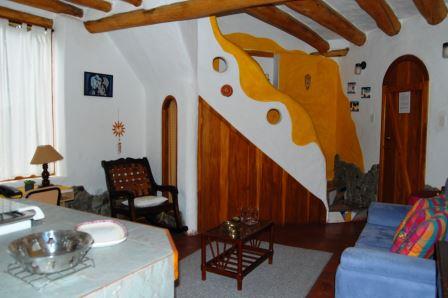 Sala y comedor bajo un techo de vigas de madera.