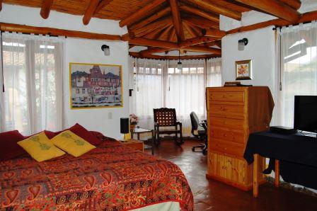Dormitorio con cama, armario y paredes claras.