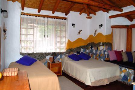 Dormitorio con dos camas y ventanales.