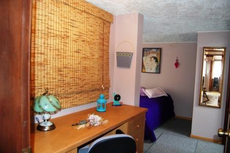 Rincón de la sala con sofá y persiana de bambú.